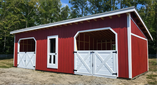 Red and white wooden shed with horse stall design in a natural setting