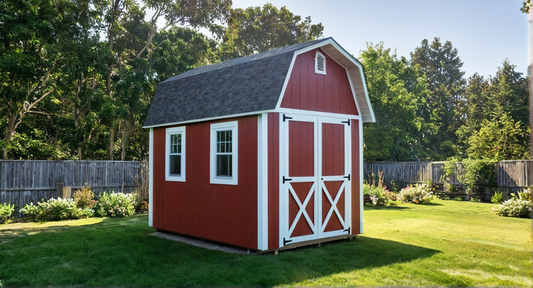 Red barn-style shed with white trim in a garden setting