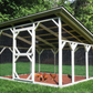 Outdoor chicken coop with a roof in a grassy area with trees in the background