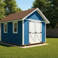 Blue storage shed with white doors in a backyard setting