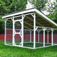 Outdoor chicken coop with a metal roof and wire sides on grass, surrounded by trees and a red fence.