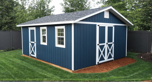 Blue storage shed with white trim on a grassy area with trees in the background