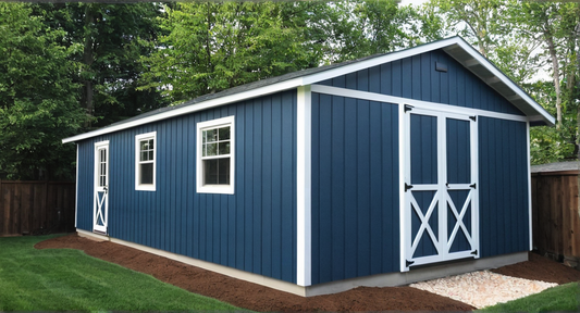 16x30 Blue storage shed with white trim in a backyard setting