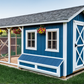 Blue and white chicken coop with a wooden fence and green grass in the background